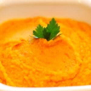 A white bowl containing carrot and parsnip puree.