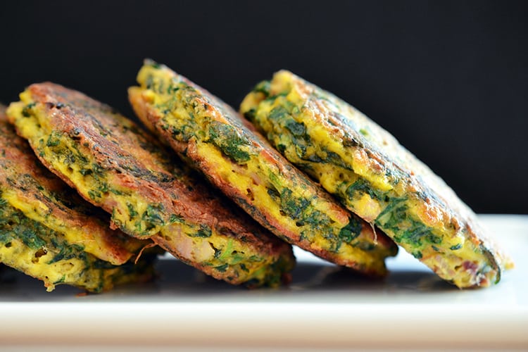 A plate of Egg Foo Young (Spinach, Egg, Ham & Coconut Pancakes) tipped on the side.