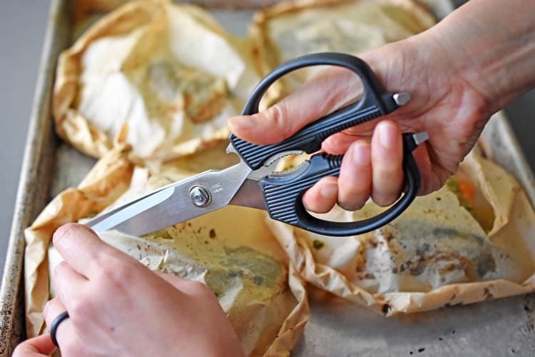 Cutting open Fiona’s Phenomenal Fish Packets with a pair of kitchen shears.