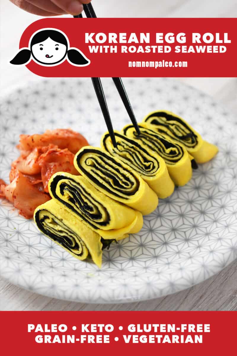 A white plate with a gray flower pattern is topped with a Korean rolled egg omelet with seaweed. There is a small pile of kimchi on the side and a pair of chopsticks is lifting up a piece. The red banner at the bottom says paleo, keto, vegetarian, and gluten-free.