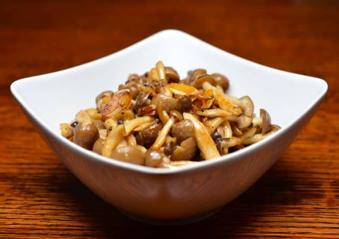 A bowl of paleo spicy sautéed mushrooms with anchovy in a white bowl.