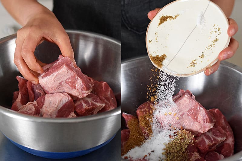 Seasoning the pork shoulder cubes with salt, cumin, red pepper flakes, and oregano