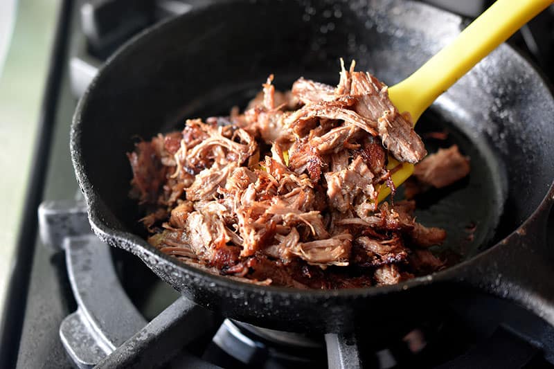 Frying Instant Pot (Pressure Cooker) Carnitas in a cast iron skillet until crispy