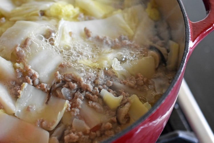 An overhead shot of Pork and Napa Cabbage Soup simmering in the pot