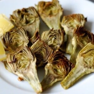 A plate of roasted baby artichokes with lemon.