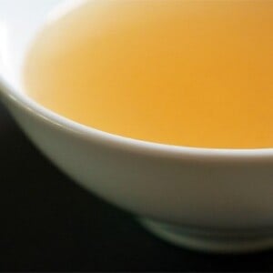 A cup filled with beef bone broth that was homemade in the slow cooker.