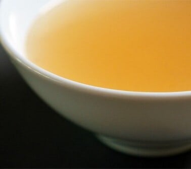 A cup filled with beef bone broth that was homemade in the slow cooker.