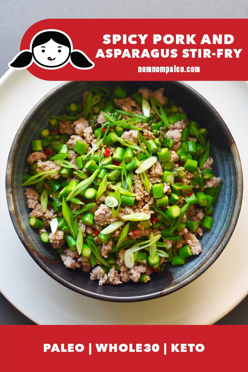 An overhead shot of a bowl of Spicy Pork and Asparagus Stir-Fry. There is a red banner with the Nom Nom Paleo logo that also states that the dish is paleo, Whole30, and Keto.