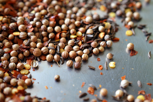 Toasting coriander seeds, caraway seeds, and pepper flakes in a dry skillet for tabil spice blend.