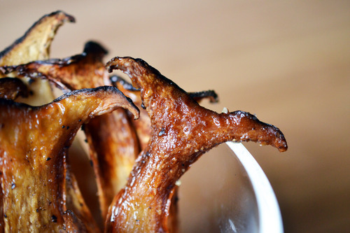 A bowl of thinly sliced crispy mushroom chips.