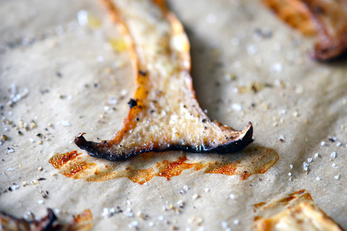 Baked crispy mushroom chips on a sheet pan.