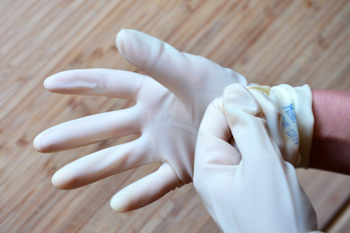Someone putting on latex gloves before making Whole30® Sriracha 