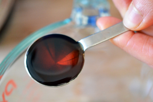 An overhead shot of a teaspoon of Red Boat fish sauce. 