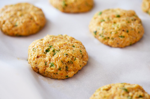 Thai Curry Crab Cakes to Go laid out in rows on parchment paper.
