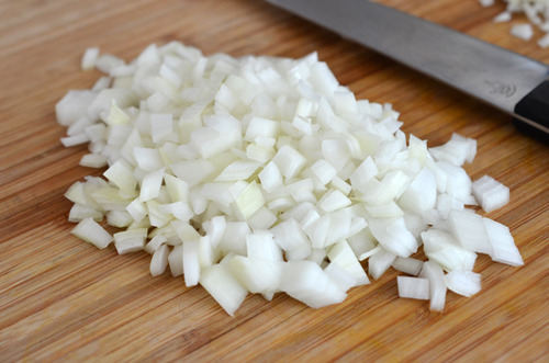 Chopped onions on a cutting board.