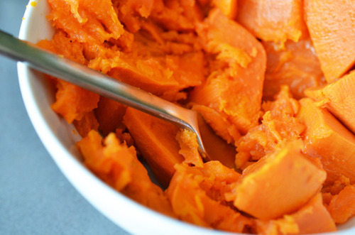 Mashing cooked sweet potatoes for lamb dosas.