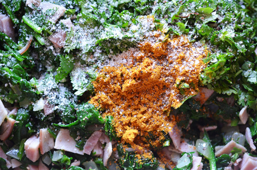 Seasonings in a skillet of sautéed spinach and ham.