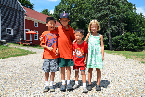 Four young children smiling at the camera.