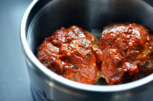 Two meatloaf muffins packed in a container.