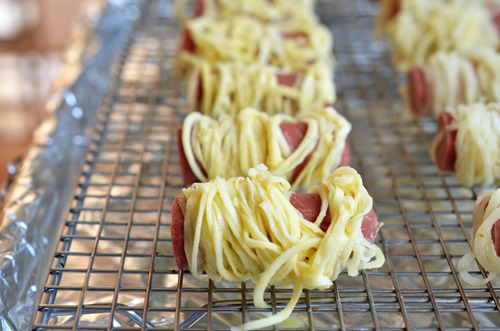 A row of paleo Yummy Mummies on a cooling rack in a rimmed baking sheet ready for the oven.