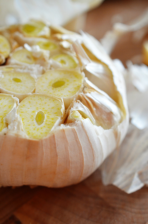 A whole head of garlic with the top cut off.
