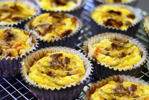 Muffin frittatas with curried beef, broccoli slaw, and mushrooms sitting on a cooling rack.