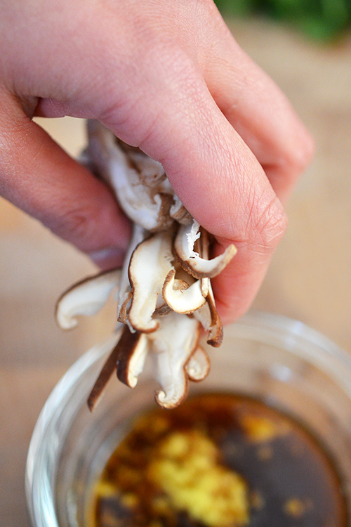 Adding a handful of thinly sliced shiitake mushrooms to the sauce.