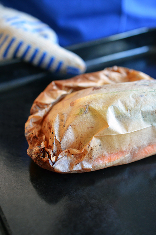 A Fish en Papillote with Citrus, Ginger, & Shiitake is removed from the oven.