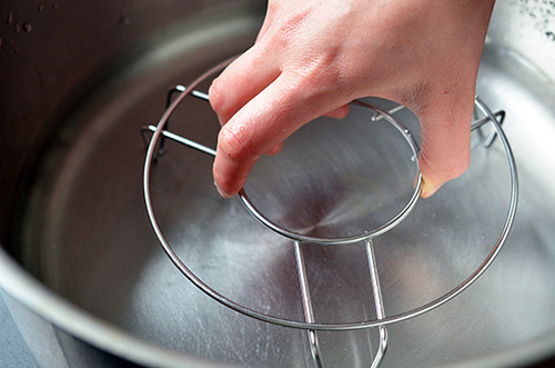 A metal steamer is placed in the pot with water.