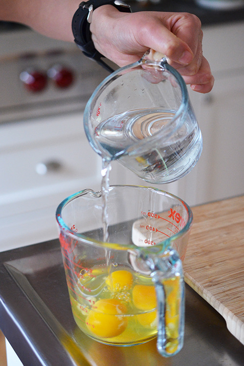 Water is poured into the cup containing the eggs. 