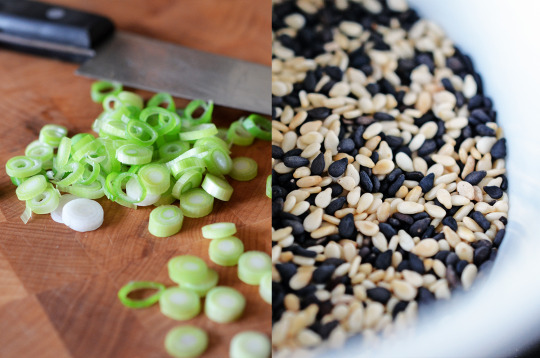 Sliced green onions on a cutting board and sesame seeds in a bowl.