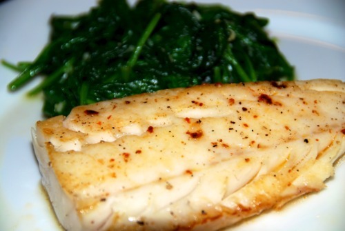 Paleo and Whole30 easy sous vide wild alaskan cod on a plate with steamed spinach.