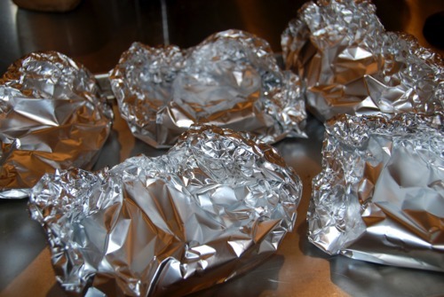 Roasted portobello mushroom packets in aluminum foil with garlic, shallots, and balsamic vinegar.