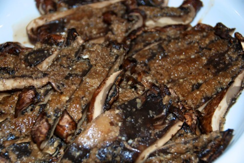 Sliced paleo roasted portobello mushroom packets in aluminum foil with garlic, shallots, and balsamic vinegar.