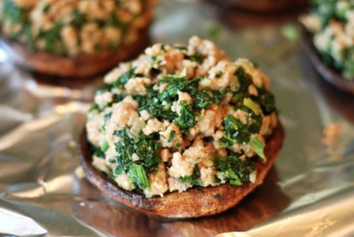 A portobello mushroom cap is stuffed with the sausage and spinach mix.