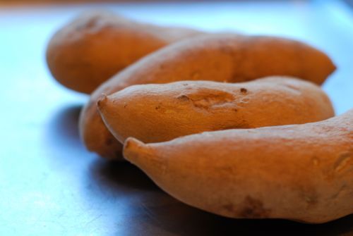 Wash and dried sweet potato yams on a countertop.