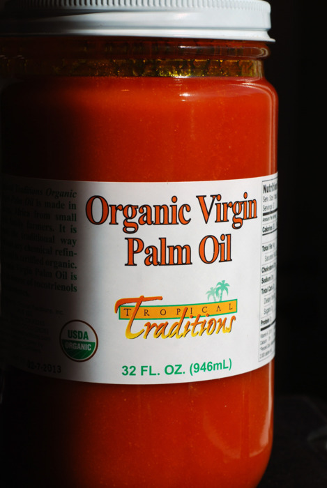 A closeup of a glass jar of organic virgin palm oil.
