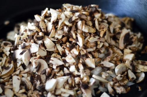 A pile of chopped cremini mushrooms in a cast iron skillet.