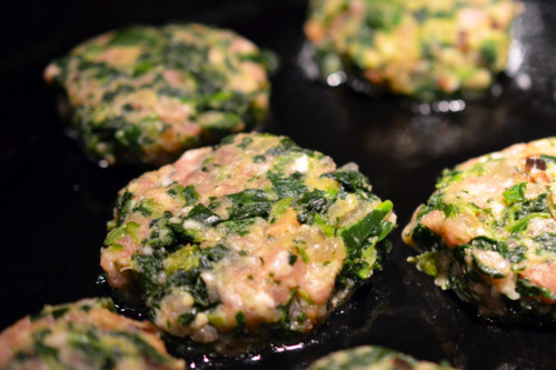 Frying the green pork sliders in a pan with shallow oil.