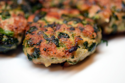 Pork sliders filled with spinach on a plate.