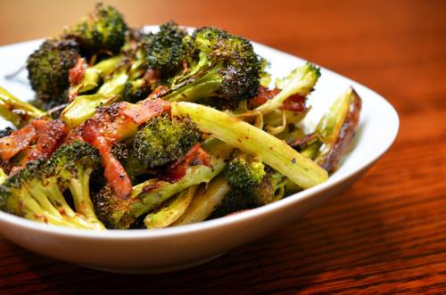 Side view of white serving bowl filled with roasted broccoli and bacon.