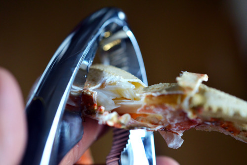Someone cracking the leg of a crab to get the meat out.