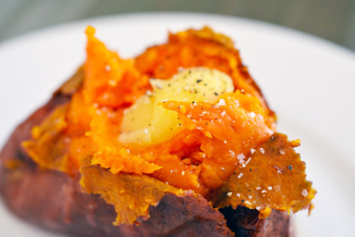 An oven-baked sweet potato topped with a dollop of homemade ghee.