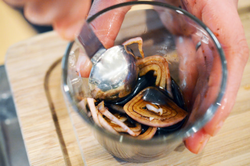 Combining sliced shallots and balsamic vinegar in a small bowl.