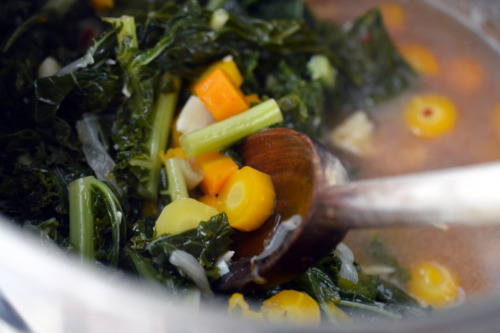 Stirring the Instant Pot braised kale and carrots with a wooden spoon.