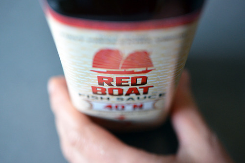 Someone grabbing a bottle of Red Boat fish sauce.
