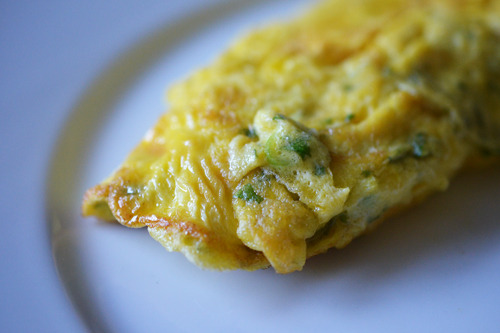 A closeup of a Thai rolled omelet on a plate.