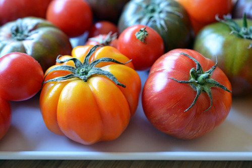 Heirloom tomatoes sitting on a cutting board.