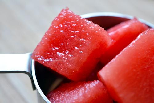 Cubed watermelon pieces in a measuring cup.
