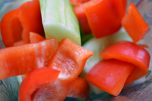 Shallots, cucumber, bell pepper, cilantro, and tomatoes in a blender to make watermelon and tomato gazpacho.